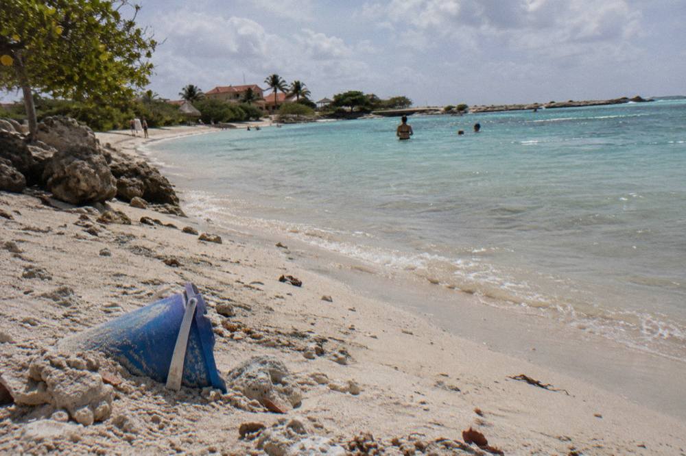 A shallow turquoise lagoon with calm water and pale sand curving along the shoreline