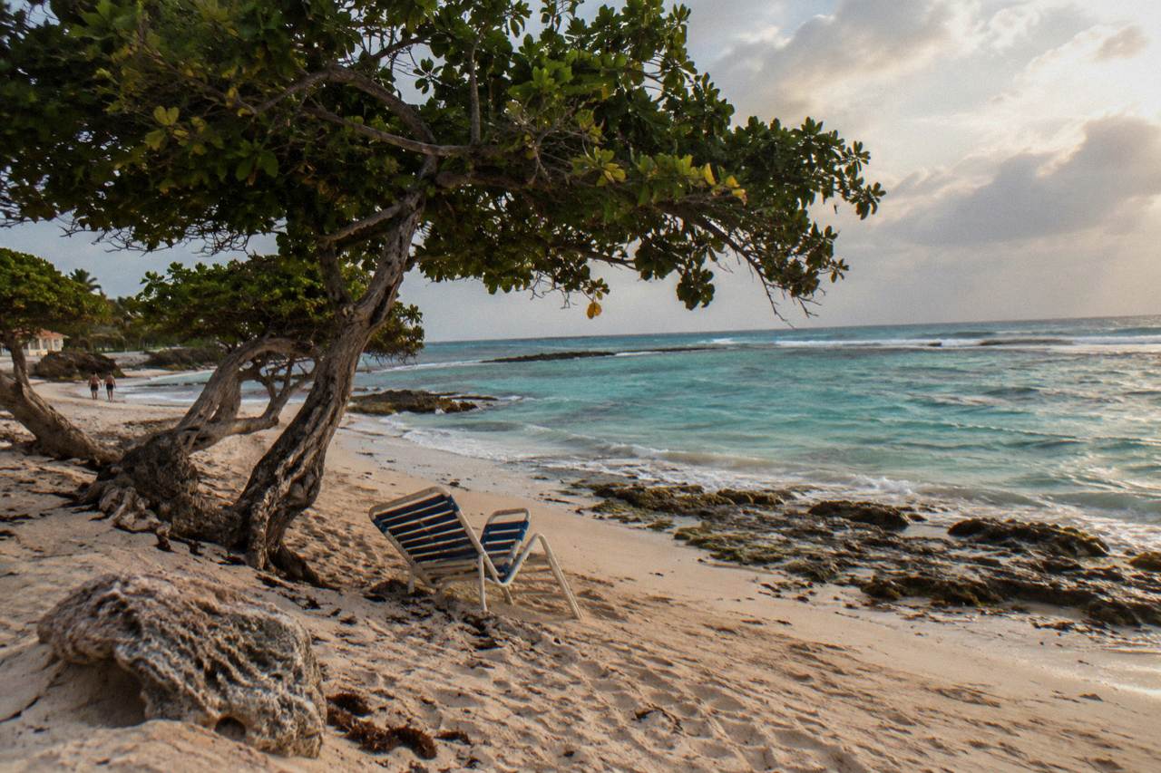 A calm turquoise bay on Aruba's west coast with white sand and clear shallow water