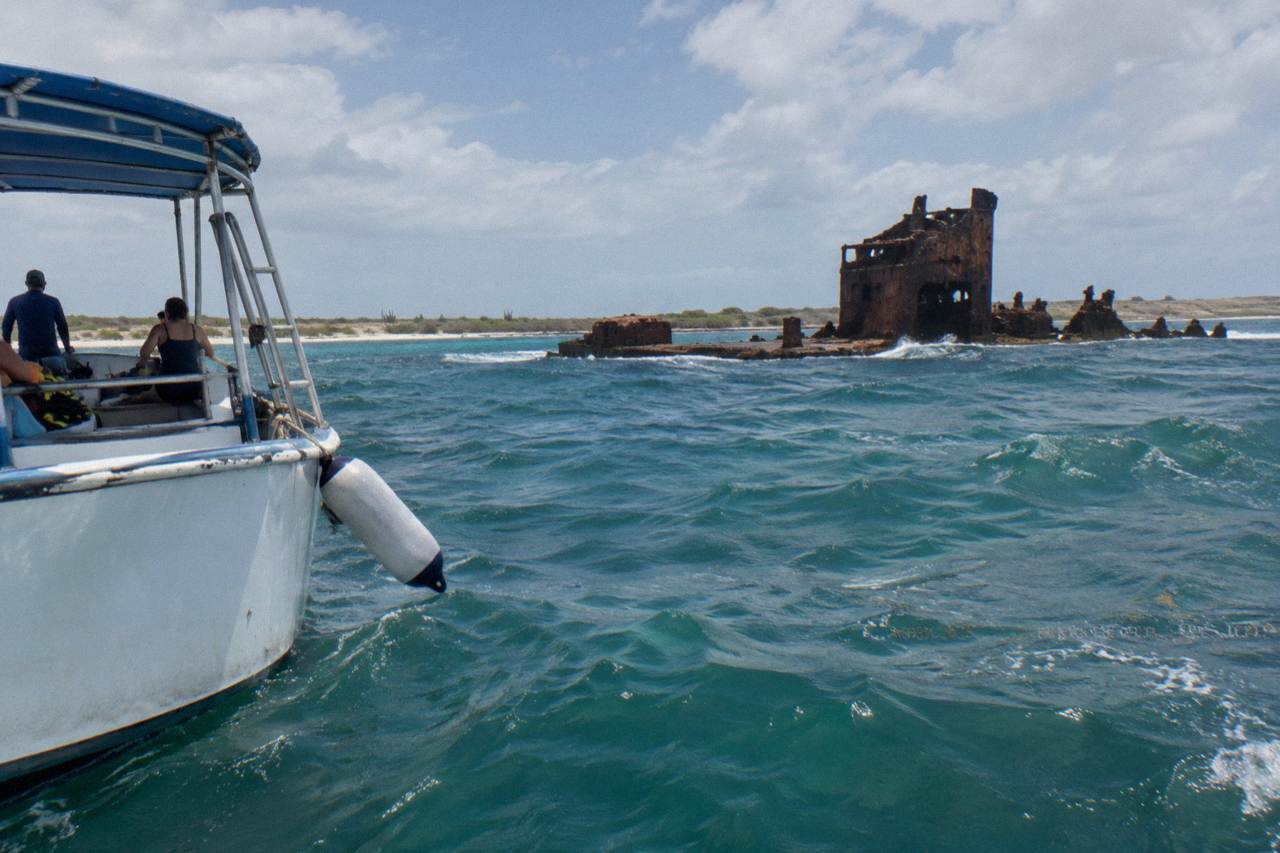 A snorkel boat moored over turquoise water near a Caribbean reef
