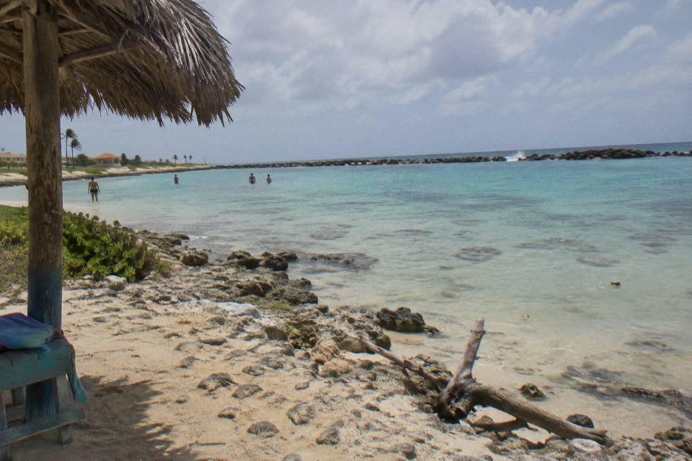 A calm sandy-bottom bay with clear shallow water and scattered coral heads