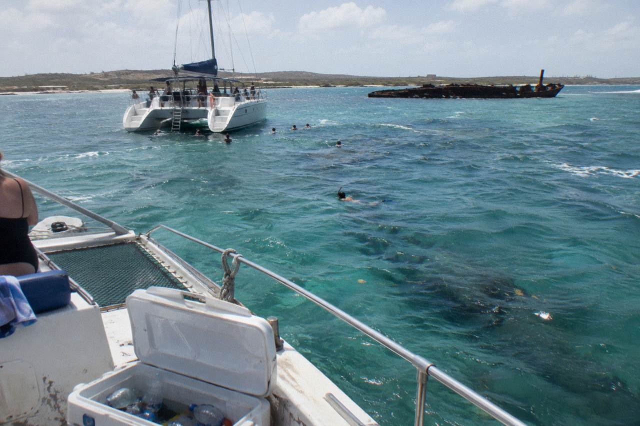 A catamaran anchored in calm turquoise water near a coral reef close to shore