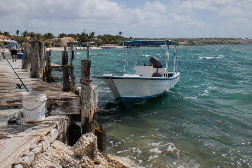 Snorkel boat moored near a beach pier under a clear sky