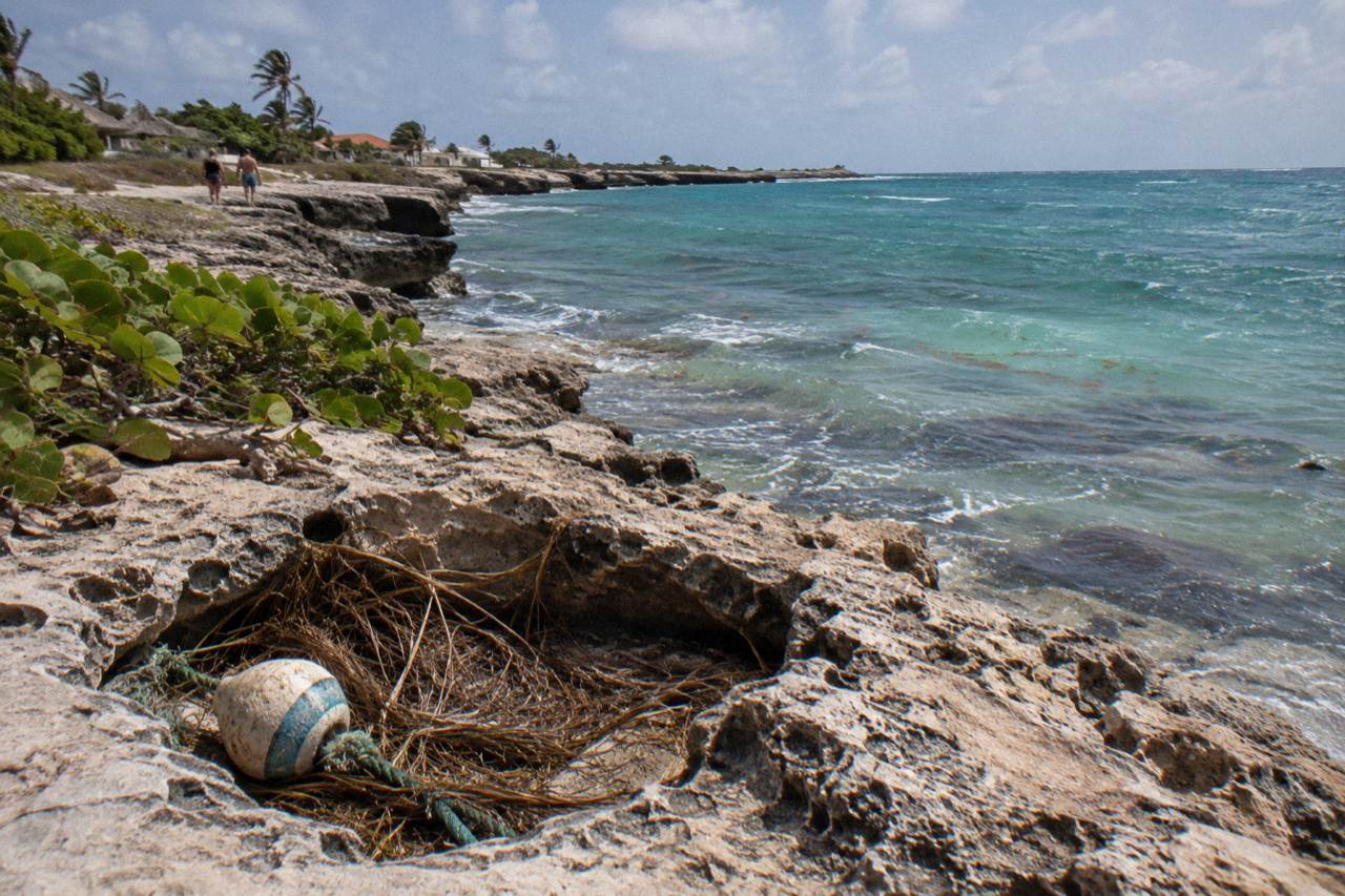 Calm turquoise water along a rocky northwest coastline of Aruba at midday