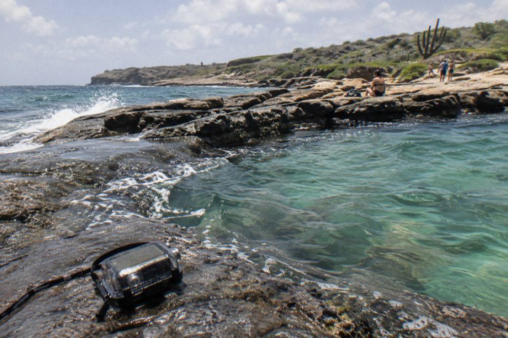 Clear shallow water over dark rock in a sheltered coastal pool