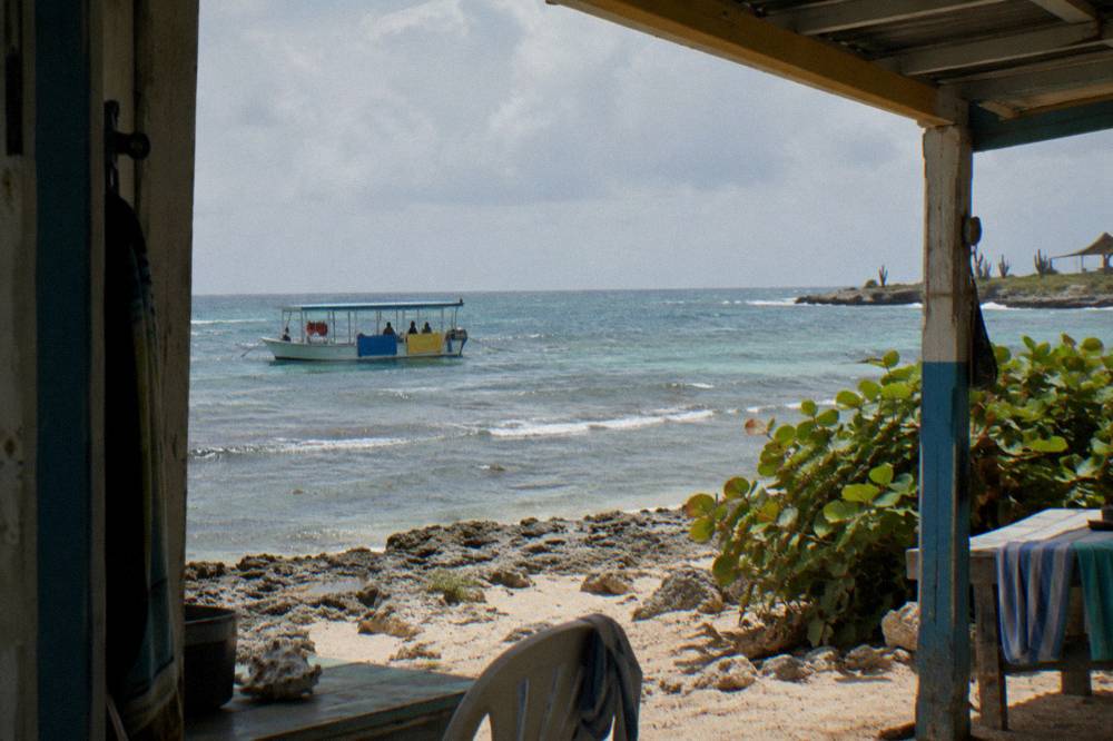 A boat deck overlooking calm reef water near a Caribbean shoreline