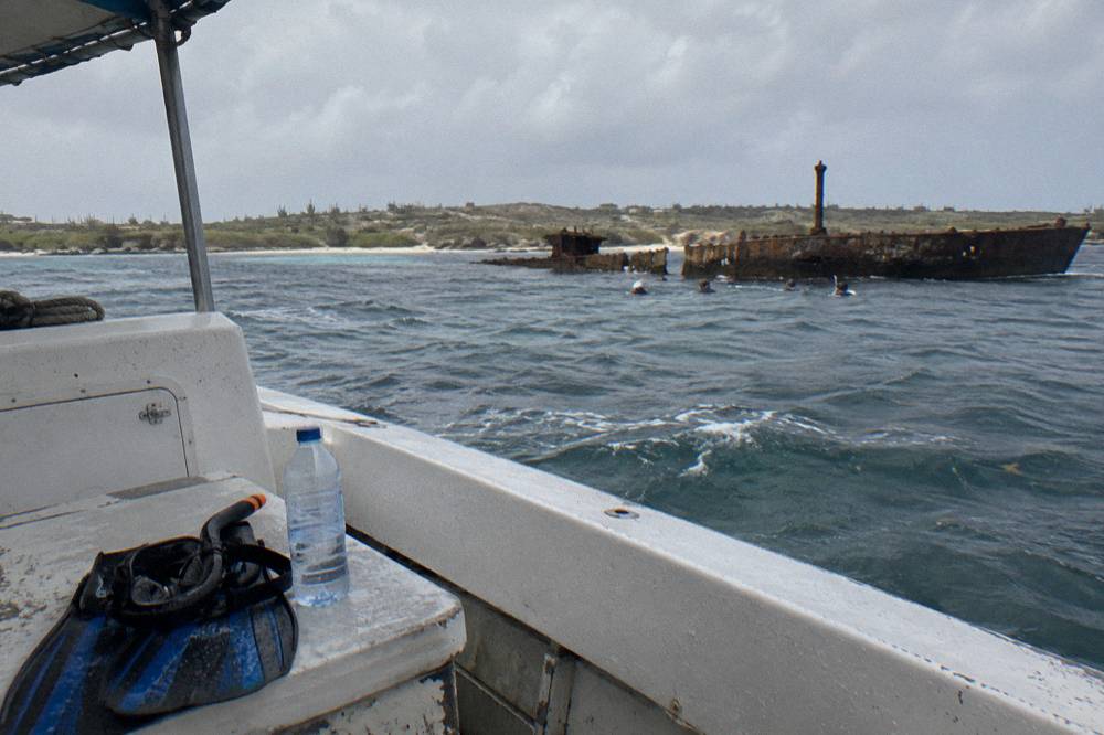 An empty snorkel mask and fins resting on the deck bench of a small boat