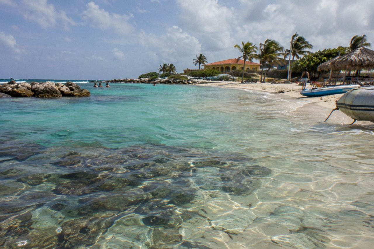Calm turquoise shallows over a coral reef close to a sandy Aruba beach