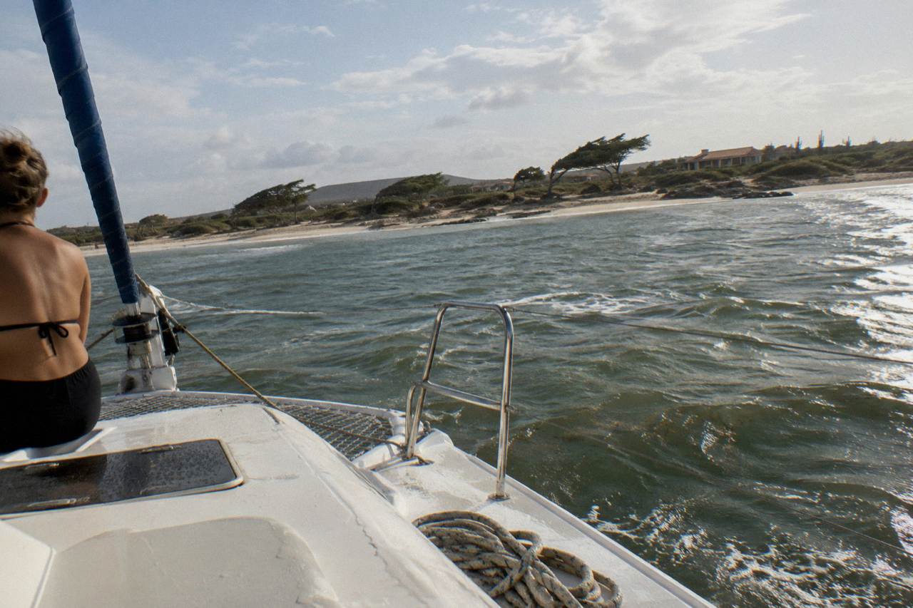 Catamaran under a warm sky near the Aruba coastline with calm water