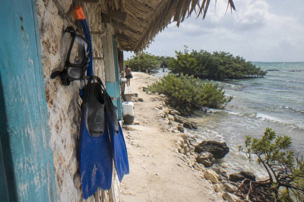 A rented snorkel set hanging on a rack beside a beach shack