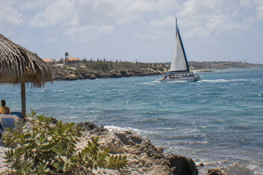 Catamaran sailing along the calm northwest coast of Aruba in late morning light