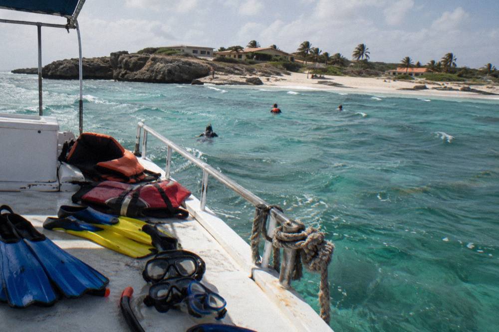 Snorkel masks fins and flotation vests laid out on a boat deck before departure
