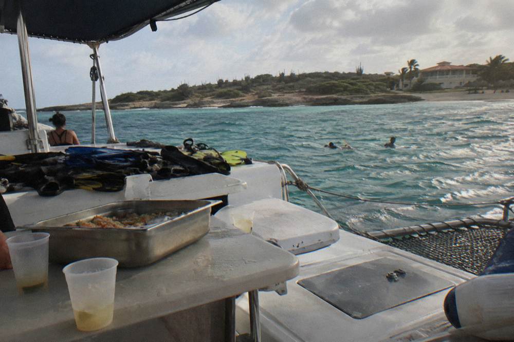 Buffet lunch and drinks arranged on a shaded catamaran deck