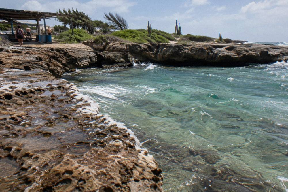 A small rocky bay with clear shallow water over a pale reef