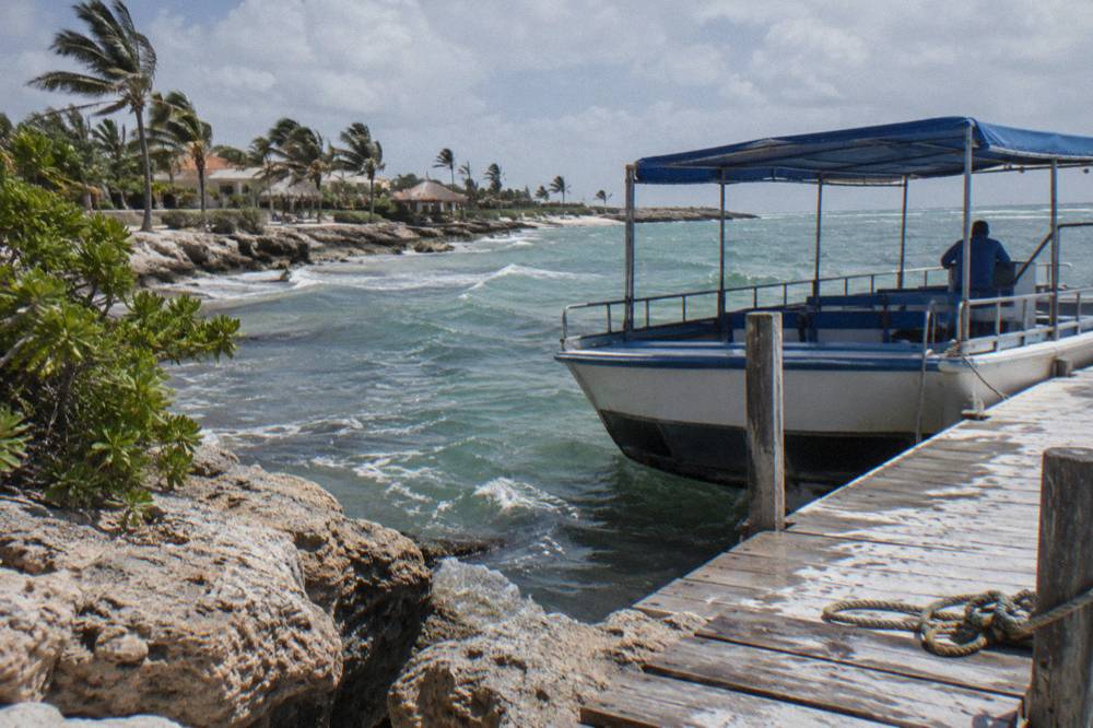 A small glass bottom boat at a wooden pier on the Aruba coast