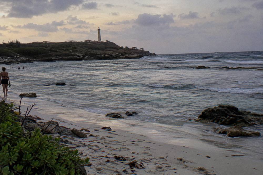 A calm beach at dusk with gentle waves over a shallow reef