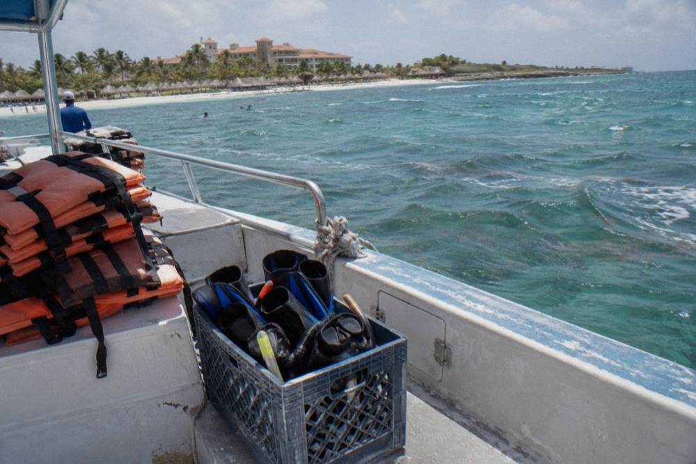 Snorkel masks and fins arranged neatly in a crate on a boat deck