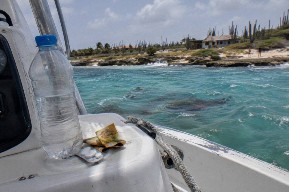 Motion sickness tablets and a packet of ginger chews on a boat console beside a bottle of water